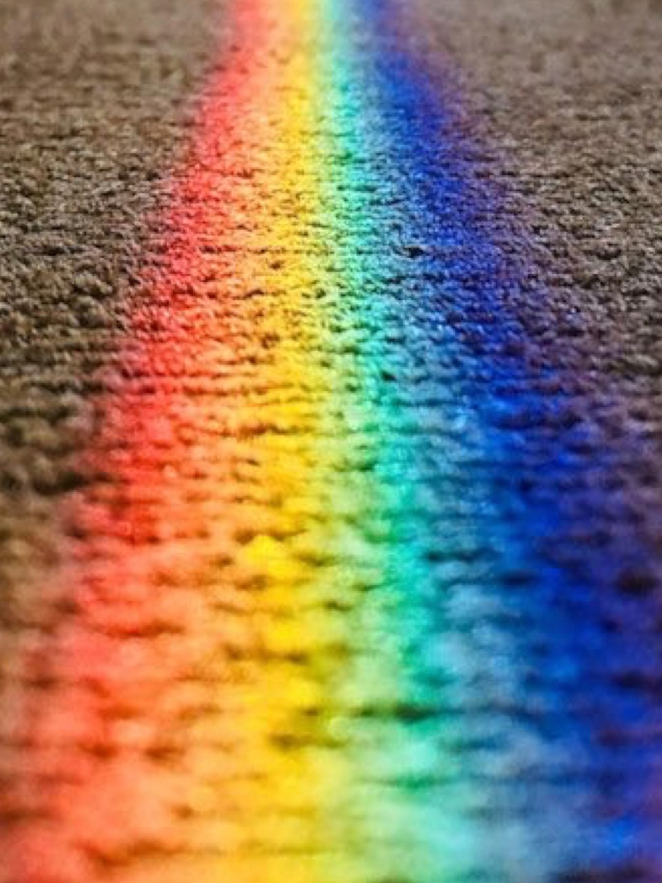 Ein Regenbogen welcher sich auf einen Teppich abzeichnet