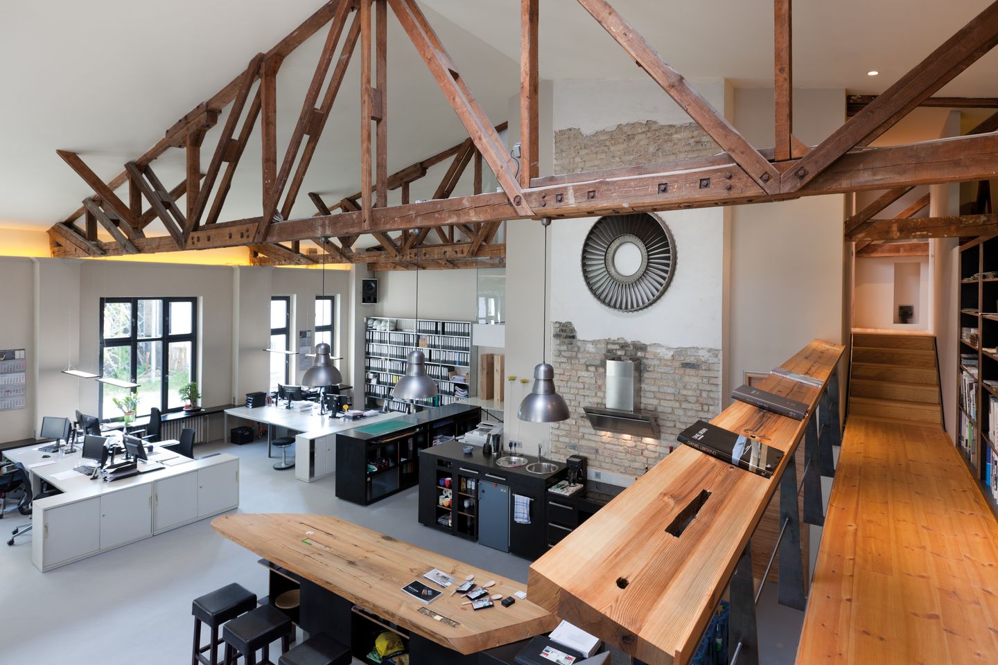 Architekturbüro mit Holztisch und mehreren Schreibtischen